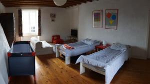 a living room with two beds and a table at Manoir de la Guerrie in Saint-Patrice-de-Claids