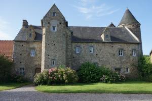 an old castle with flowers in front of it at Manoir de la Guerrie in Saint-Patrice-de-Claids