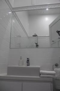 a bathroom with a sink and a mirror at Mentor Chambers Apartment Bed & Breakfast in West Wyalong