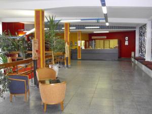 an empty lobby with chairs and tables in a building at Internationales Gästehaus in Jena