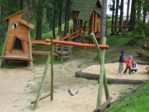 three children playing in a playground with a swing at Apartamenty Viva Maria in Zakopane