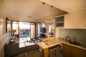 Una cocina y una sala de estar con un sofá y una mesa. en Kuta Reef Apartments, en Kuta