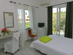 a bedroom with a bed and a desk and a window at Akrotiri Hotel in Chania
