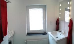 a white bathroom with a window and a sink at Schwalbennest Ferienvermietung Arendholz in Hüde