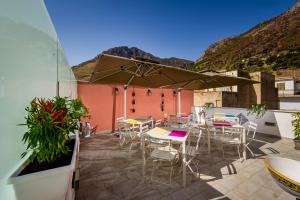 a patio with tables and chairs and an umbrella at Antico Canale in Castellammare del Golfo