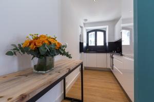 une cuisine avec une table et un vase de fleurs. dans l'établissement Florella Antibes Apartment, à Cannes