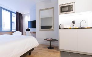 a hotel room with a bed and a table and a mirror at Studio luxe hyper centre piscine in Bordeaux
