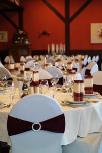 a long table with white chairs and wine glasses at Hotel Zum Jägerhaus in Vreden