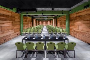 una sala conferenze con un lungo tavolo e sedie verdi di IOTA Hotel Tbilisi a Tbilisi City