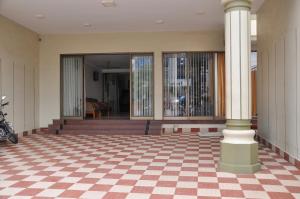 a lobby with a checkered floor and a column at Hotel Rajam in Kanyakumari