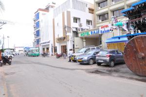 a city street with cars parked in front of buildings at Hotel Rajam in Kanyakumari