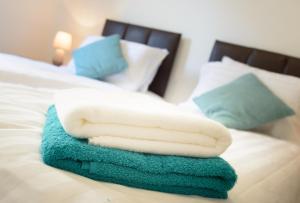 una pila de toallas sentadas encima de una cama en Apartment D204 en Northampton