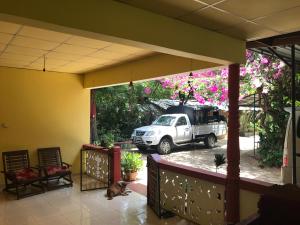 un camión blanco estacionado en un estacionamiento con flores en Kalana Homestay, en Sigiriya