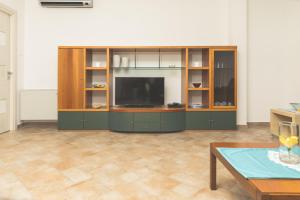 uma sala de estar com um centro de entretenimento com uma televisão de ecrã plano em Villa Pomelia em Balestrate