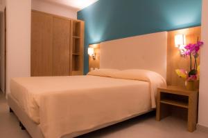 um quarto com uma cama branca e uma parede azul em Hotel Maria em Golfo Aranci