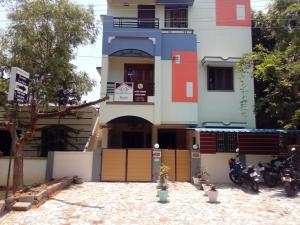 a building with two motorcycles parked in front of it at Barnabas Homestay in Thanjāvūr