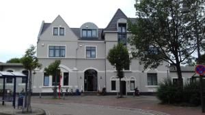 a large white building with a black roof at Historisches Hotel Wildeshauser Bahnhof in Wildeshausen