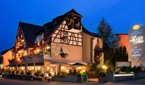 a large building with lights on it at night at Logis Hotel Le Parc & Spa in Saint-Hippolyte