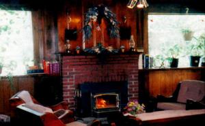 een woonkamer met een stenen open haard en stoelen bij Austrian Haus Lodge in West Dover