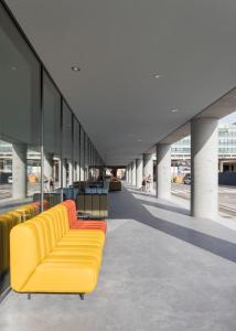 a row of yellow couches in a building at a&o Hostel Venezia Mestre in Mestre