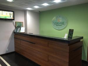 a cashier counter with a welcome sign on the wall at Hotel Maerkli in Santo Ângelo