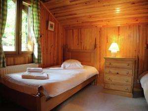 Un pat sau paturi într-o cameră la Cozy chalet in the woods of the beautiful Dordogne