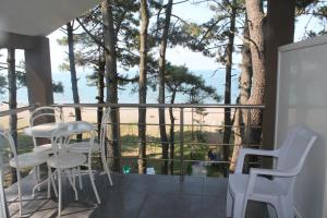 un balcone con sedie bianche e vista sull'oceano di Mana-Mana a Grigoleti