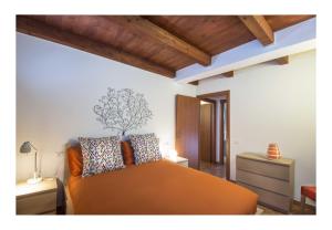 - une chambre avec un lit orange et un plafond en bois dans l'établissement Il Borgo di Tresana, à Tresana