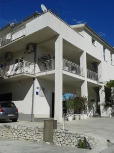 a white building with a car parked in front of it at Haus Pehar in Baška Voda
