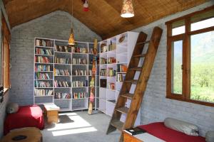 a room with a library with book shelves and a ladder at Larisa Resort Manali in Manāli