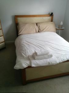 a bed with white sheets and towels on it at Fitzroy Chiswick Apartment in London