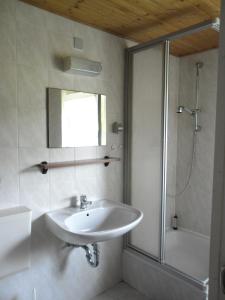 a white bathroom with a sink and a shower at Kleines Haus am Wald in Benshausen