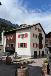 a building with red windows and benches in front of it at Haus Dorf 7 in Saas-Grund