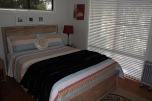um quarto com uma cama e duas janelas com persianas em Francisca's Cottage em Denmark