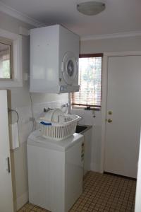 uma cozinha com um lavatório e uma máquina de lavar roupa em Francisca's Cottage em Denmark