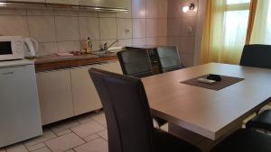 cocina con mesa, sillas y microondas en Apartments Škrobot en Senj