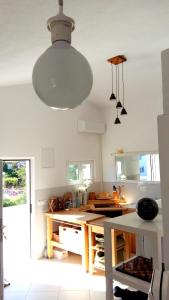 a kitchen with a table and a large light fixture at Apartments House of Art in Nin