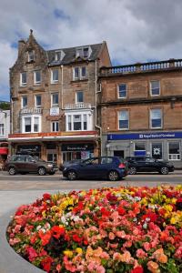 un lecho de flores en la calle frente a un edificio en Kings Arms Holiday Apartments, en Oban