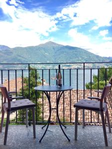 einen Tisch mit einer Flasche Wein und zwei Stühle auf dem Balkon in der Unterkunft Lario View Apartment in Acquaseria