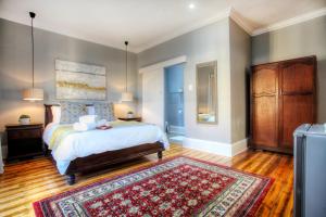 una camera con letto e tappeto di 23 On Glen Guest House a Port Elizabeth