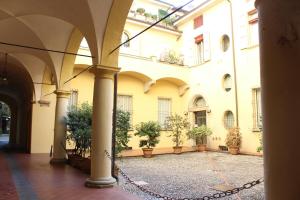 Un patio de un edificio con plantas en macetas. en Rooms H Ercolani, en Bolonia