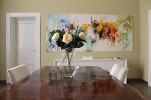 un jarrón de flores sentado sobre una mesa en Rooms H Ercolani, en Bolonia 22 fotos más