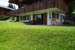a house with a lawn in front of it at Chalet Lucille in Leysin
