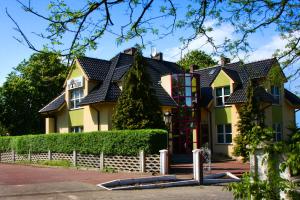 a yellow house with a black roof at Pensjonat Pod Kasztanami in Głogów