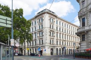 Hotel Am Schubertring في فيينا: مبنى ابيض كبير على زاوية شارع