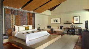 a bedroom with a large bed and a couch at Ametis Villa in Canggu