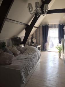 1 dormitorio con cama grande y ventana grande en De Snoeperij, en Dirksland