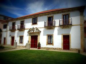 a large white building with red doors and windows at Casa Do Brasao in Tabuaço