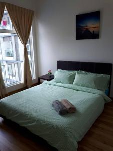 a bedroom with a bed with a green comforter at 888@D'Perdana Sri Cemerlang in Kota Bharu