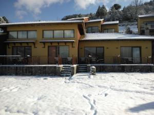 uma casa com neve em frente em Olvios Hotel em Gkoura